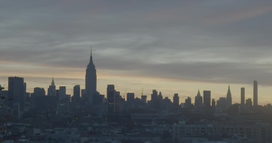 A dim city skyline on a cloudy evening