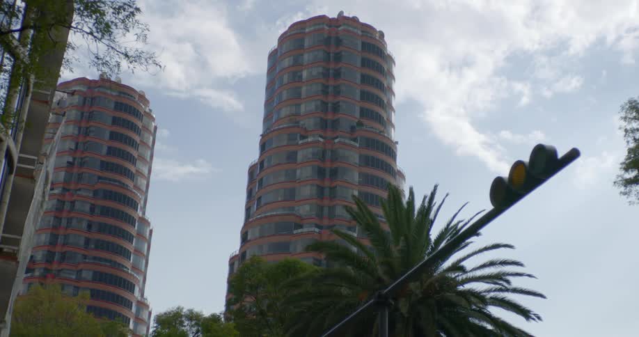 Clouds float over a tall glass building