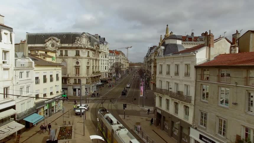 View of a city street with people walking along and a trolley