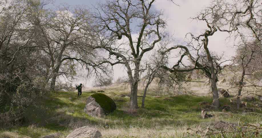 A man is hiking in the distance down the hill