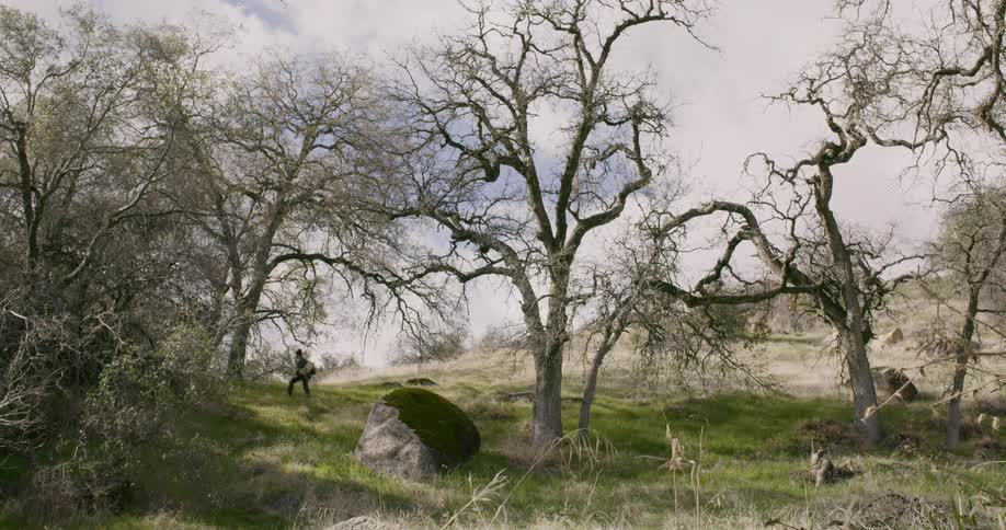 Man with backpack walking up a hill