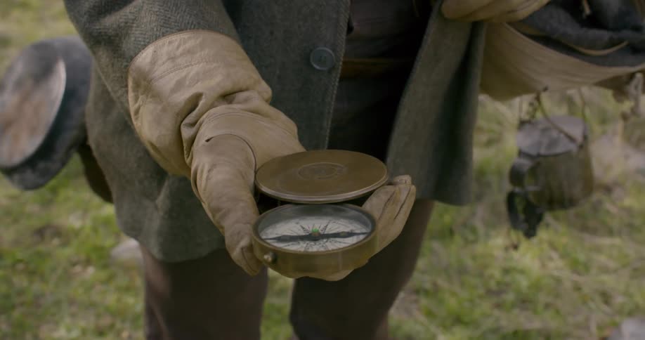 A man looking at his compass in a confused manner