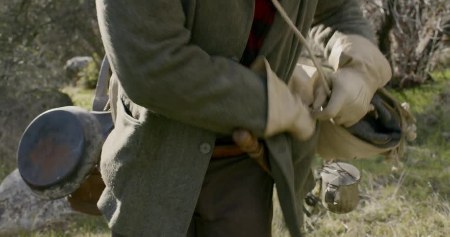 A man pulls out a compass while hiking