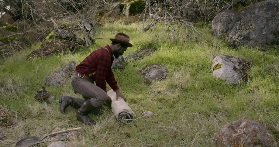A man i setting up camp on the field