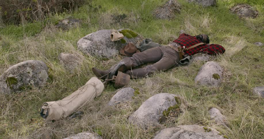 A man is sleeping on the field