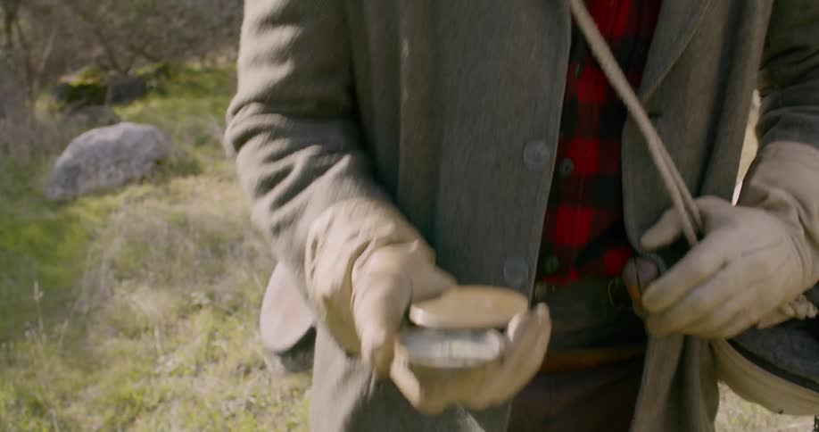 A man checks a compass while hiking