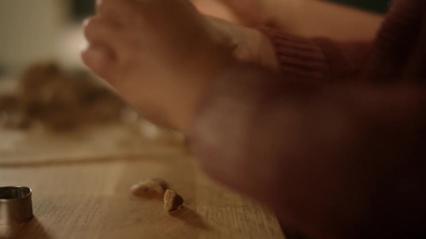A person is using their hands to form a tiny object