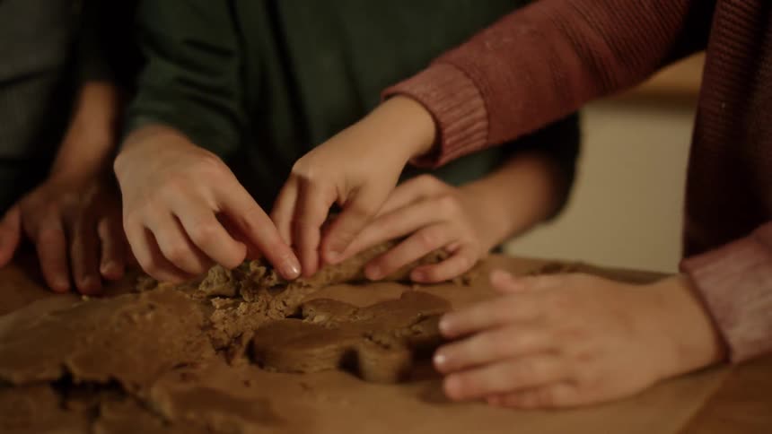 People are removing dough to make a gingerbread man