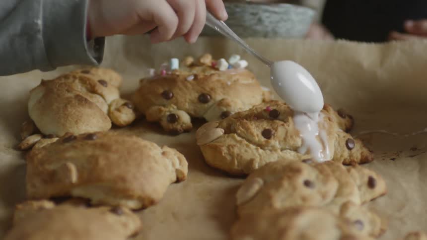 A person spreads frosting on a pastery