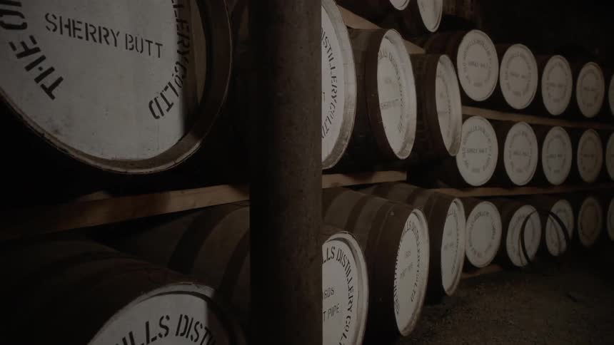Barrels of whiskey sit on shelves
