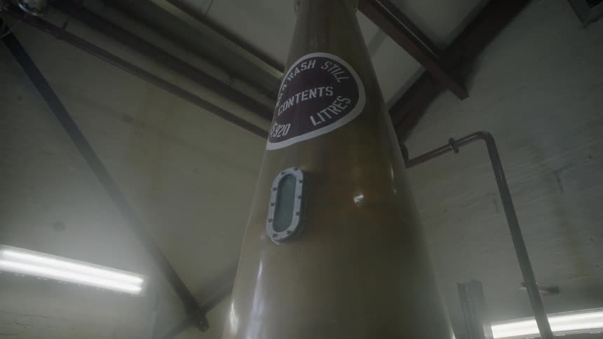 A vat stretches up towards the ceiling of a building