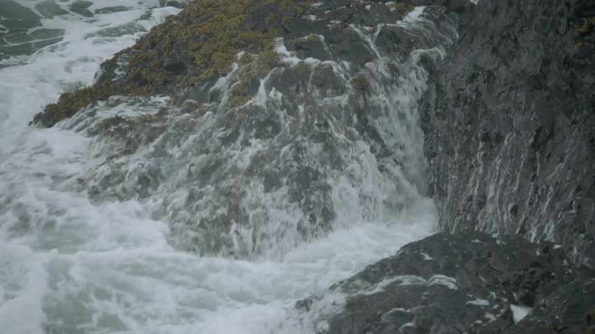 Ocean waves crash into a rocky shoreline