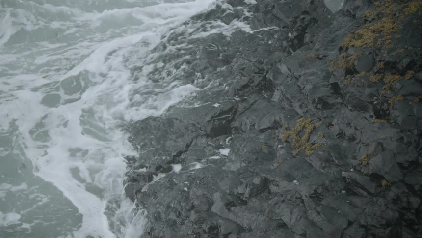 Waves splash up against rock