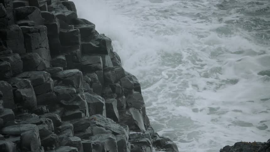 Camera shot panning downwards on a ocean coastline