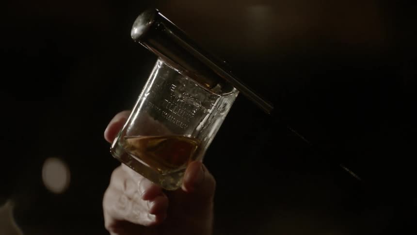Alcohol being poured into a shot glass