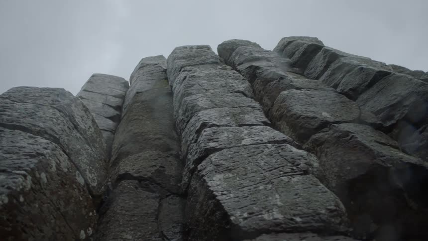 A large rock structure looms into the sky