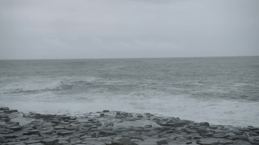 Waves roll in against the rocky shore on the giants causeway