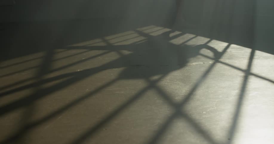 The shadow of a woman dancing on a concrete floor