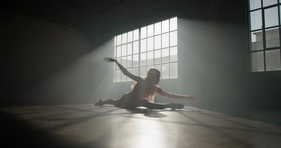 A dancer performs a split after a twirl and continues dancing on the studio floor