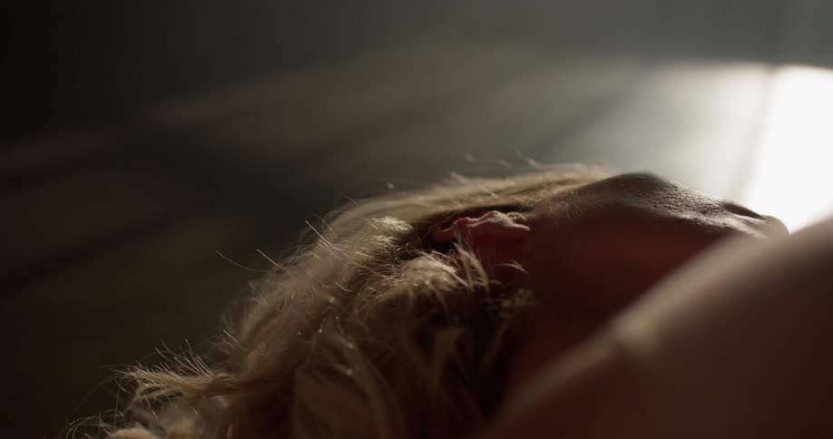 A caucasian female laying on the floor moving her arms