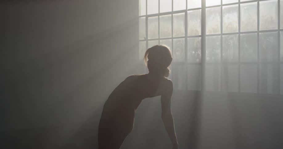 A young dancer does a back flip in a studio