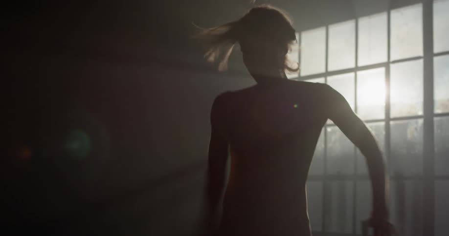 Woman twirls in dark room