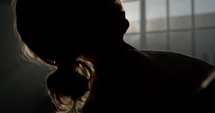 A female dancer twirls in front of a sunny window in a dance studio
