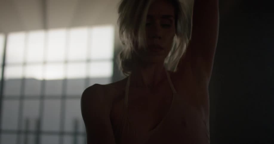 A woman slowly dances in a dance studio in the early morning