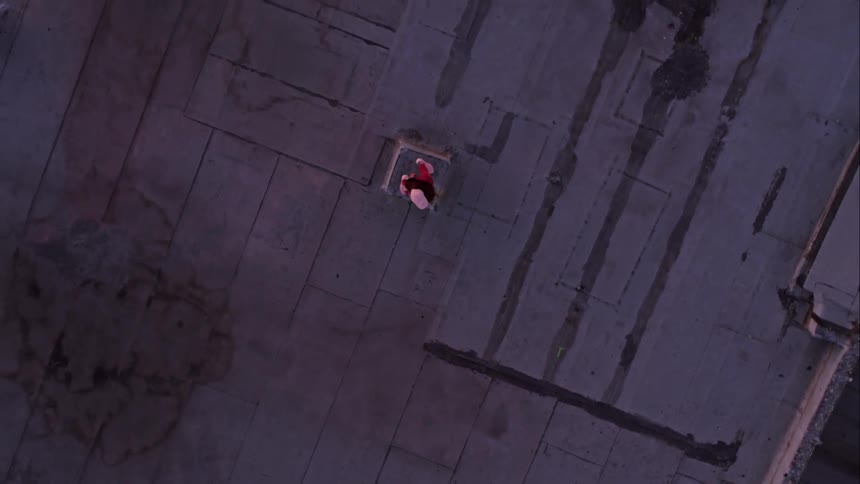 A person hip hop dancing on a rooftop in a city