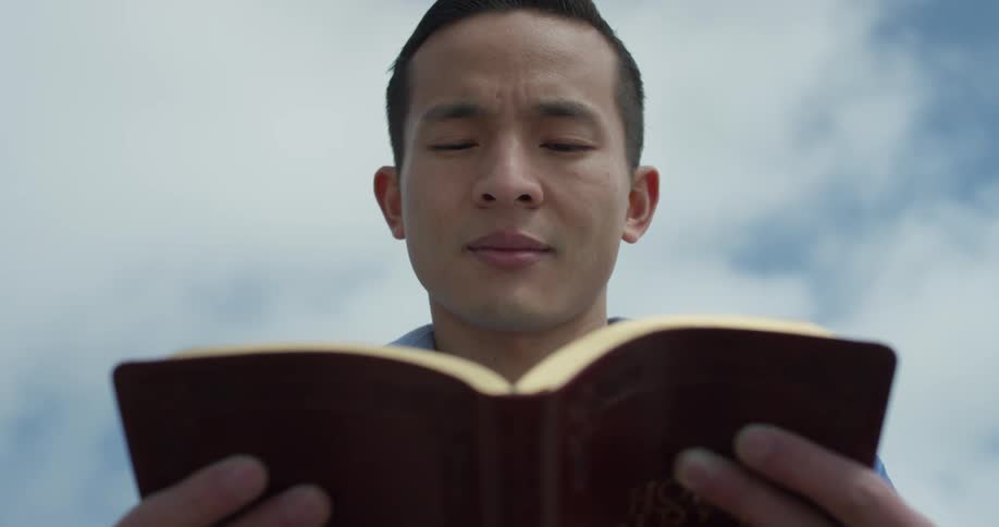 A man is reading a book outside