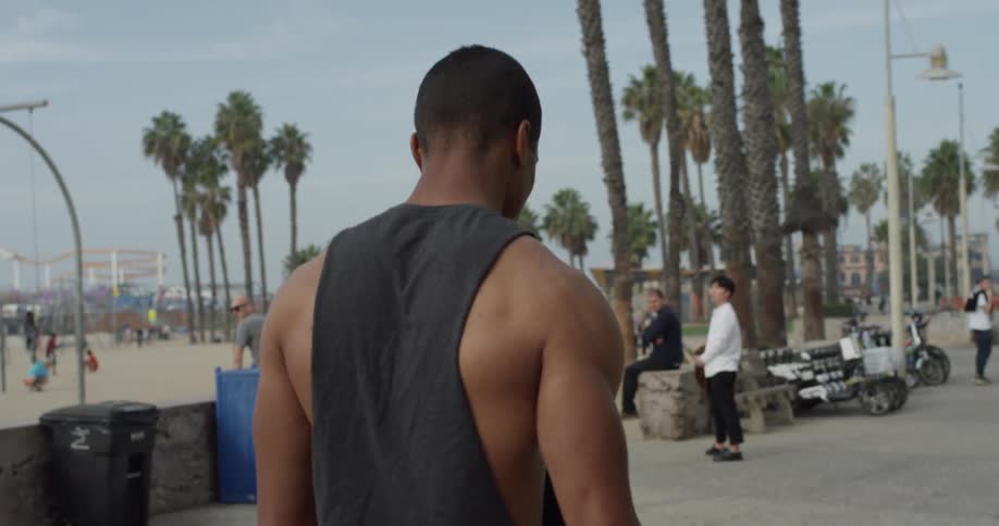 Man walks along a busy beach boardwalk