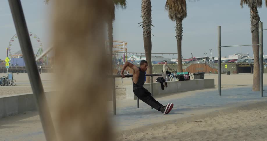 A man exercising on a beach boardwalk
