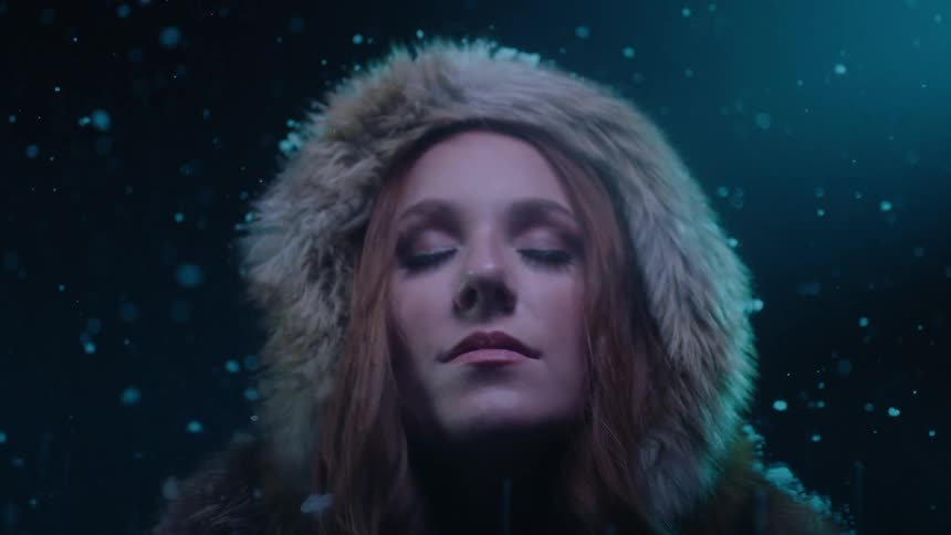 Snow falling on a woman in a fur lined hood