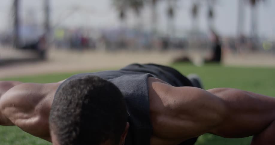 A man on the grass doing push ups