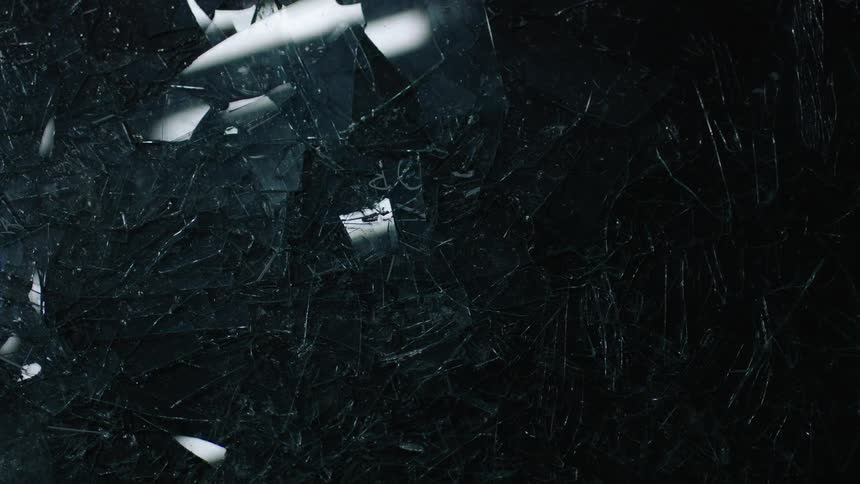 An overhead view of a thick layer of glass shards reflecting moving lights above