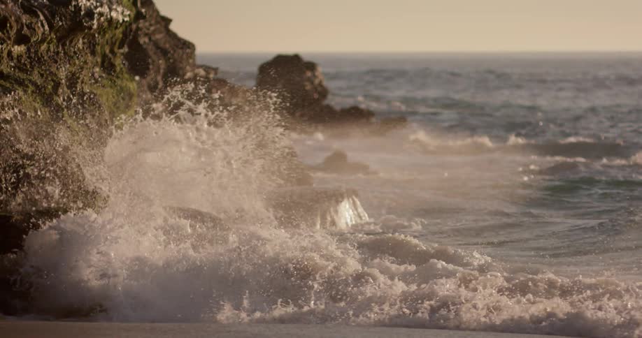 Waves bounce off the rocks on the shore