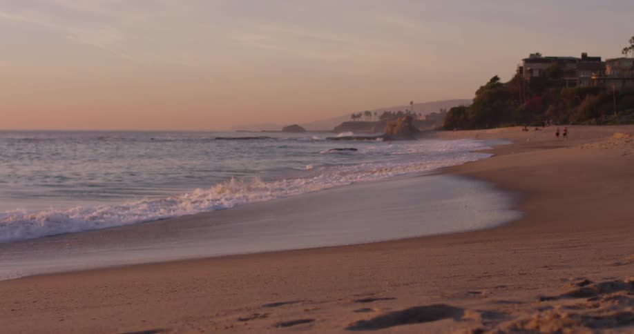 Waves crashing on the shoreline on a deserted beach at sunrise
