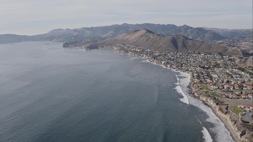 Homes and buildings overlooking ocean beaches as waves come to shore