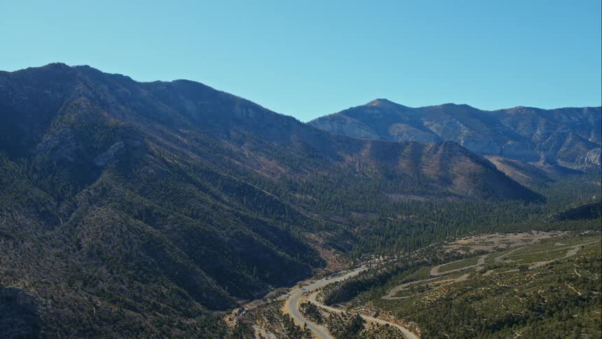 A road with mountains and forests in the background