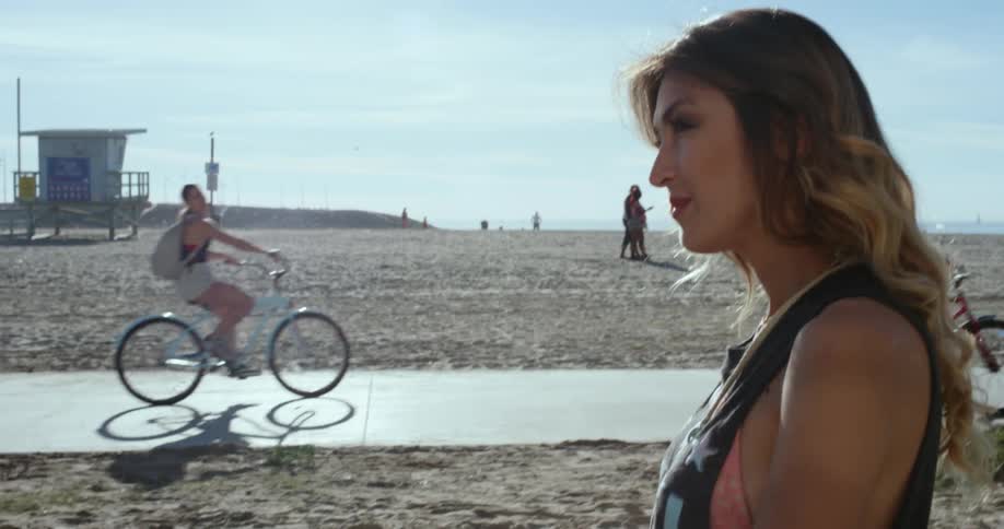 A woman walks down a beachside road