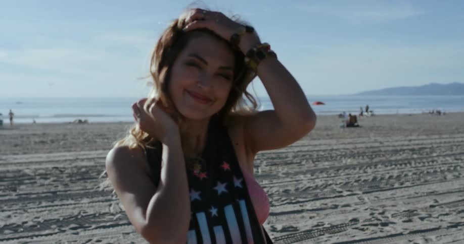 Woman smiles as she walks along beach