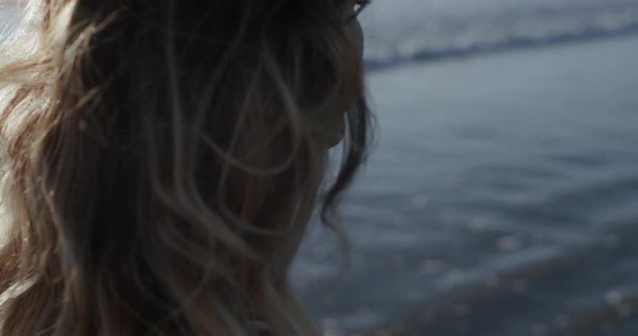 A woman stares out to the ocean water