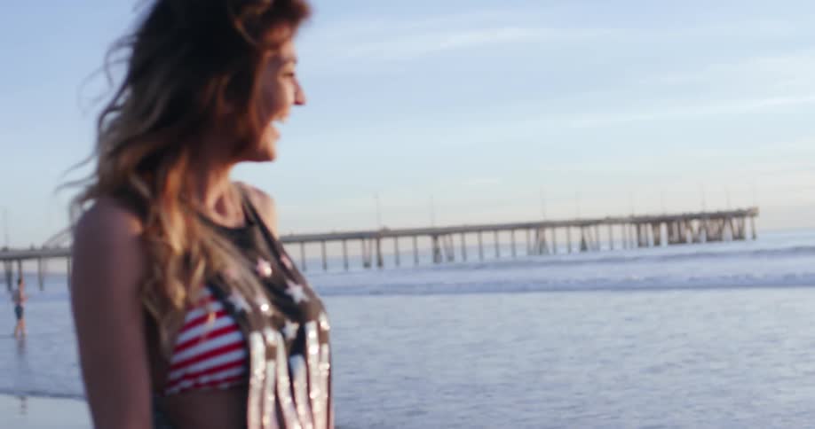 A woman throws something into the ocean