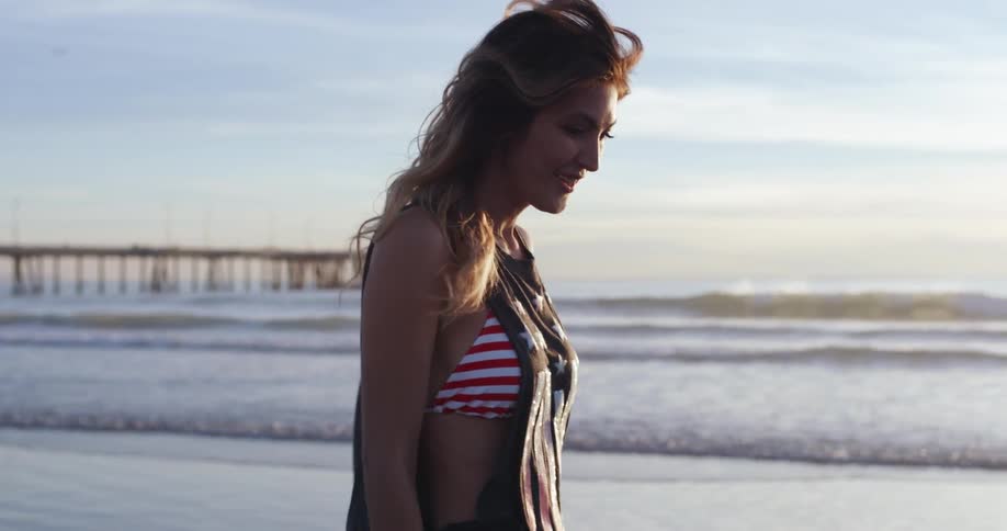 A young woman walks on a beach