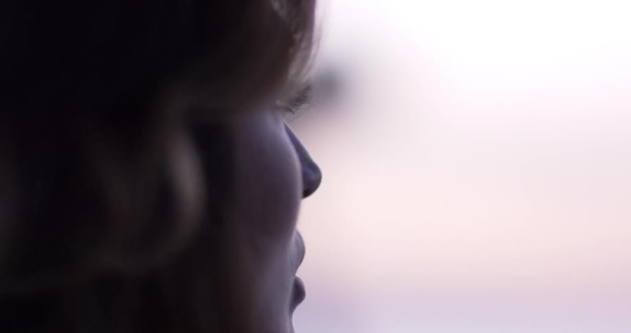 Woman wearing headphones and listening to music looks a headduring daylight