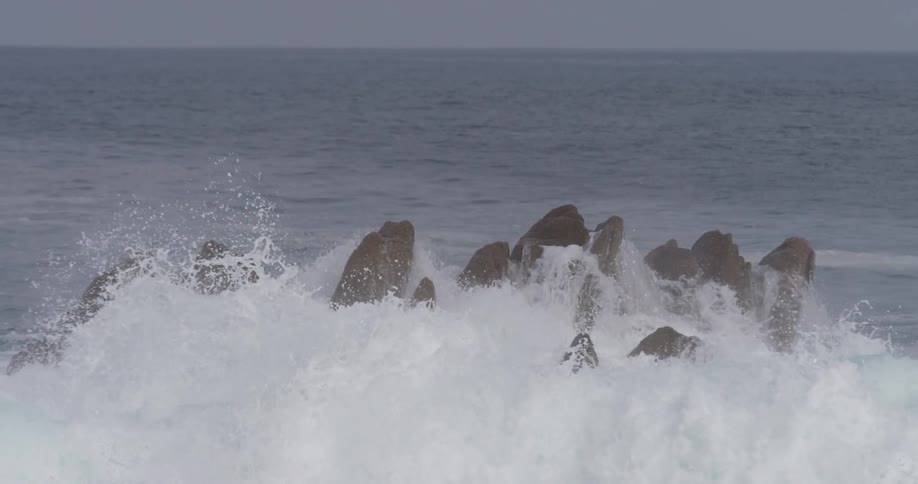 Waves in the ocean crashing onto large rocks