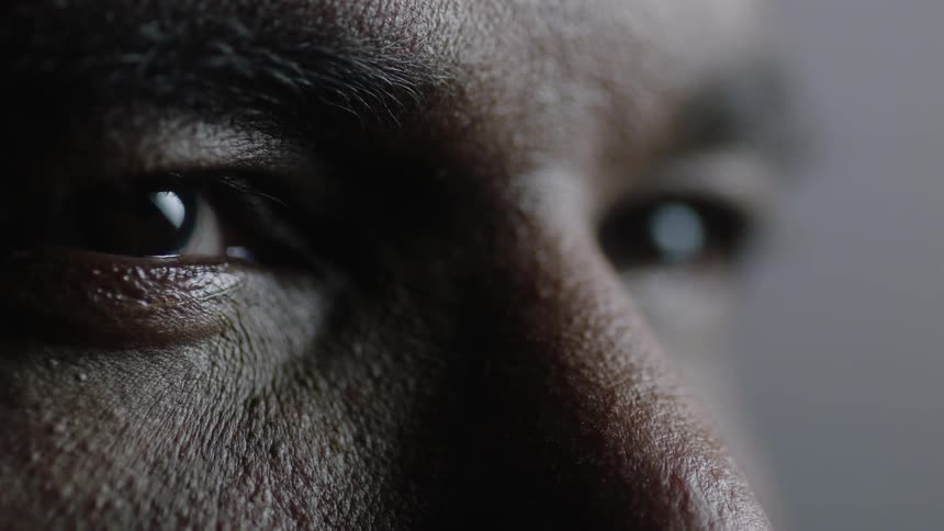 A person squints as light passes over their eyes