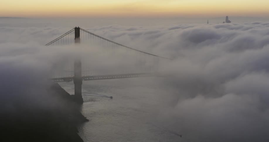 Clouds covering the golden gate bridge and water below