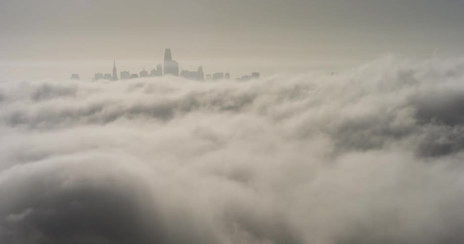 The skyline of a city beyond a sea of clouds