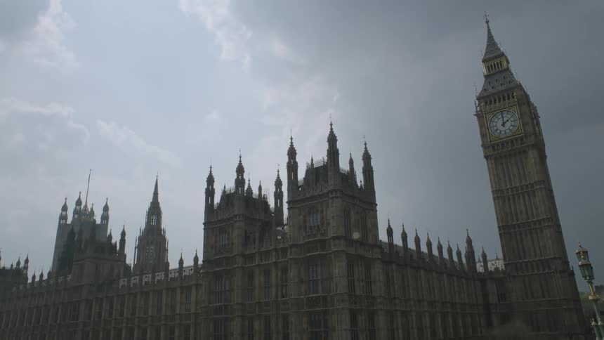 A large building has a clock tower on a cloudy day